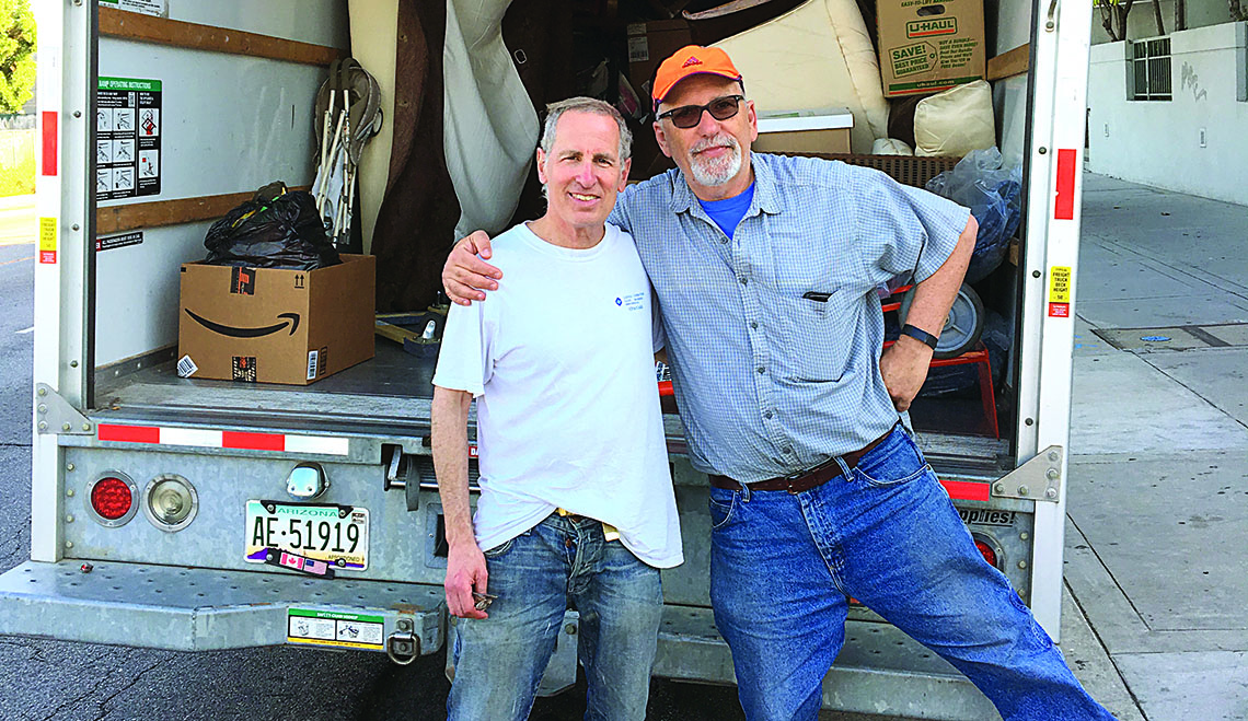 Temple Beth Am members Gary Bachrach (left) and Mathis Chazanov pose behind of a U-Haul truck loaded with donated household items for refugee resettlement in San Diego.  Photo by Tyson Roberts.