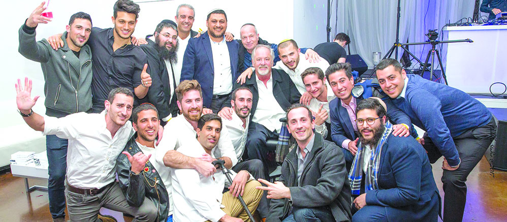 Soldiers who traveled to Los Angeles as part of Lev Chayal “Trip of a Lifetime” gather around businessman and philanthropist Marvin Markowitz (top row, seventh from left, seated). Photo by Debra Halperin Photography. 