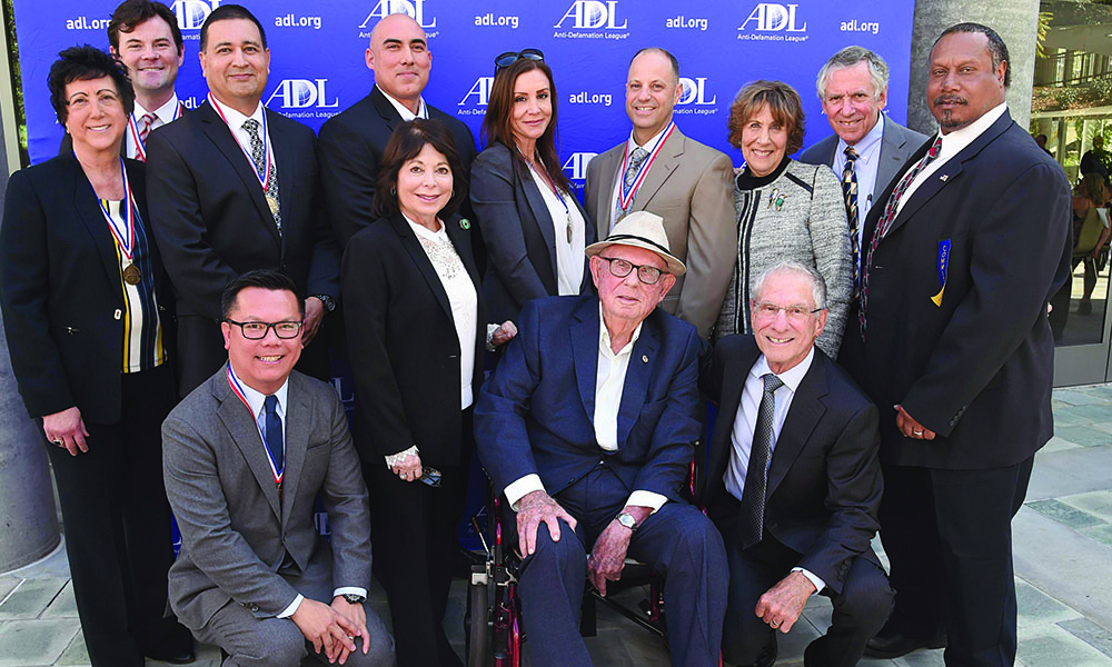 LAPD and Bureau of Alcohol, Tobacco, Firearms and Explosives investigators and L.A. city attorneys, who were honored for their takedown of a white supremacist gang in the San Fernando Valley, come together with Joseph Sherwood (seated, front row) and his son, Howard (crouching, far right) at the Anti-Defamation League’s Helene & Joseph Sherwood Prize for Combating Hate luncheon and awards event.