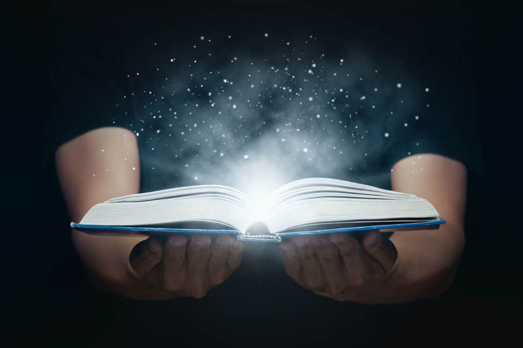 Midsection of woman reading book against black background